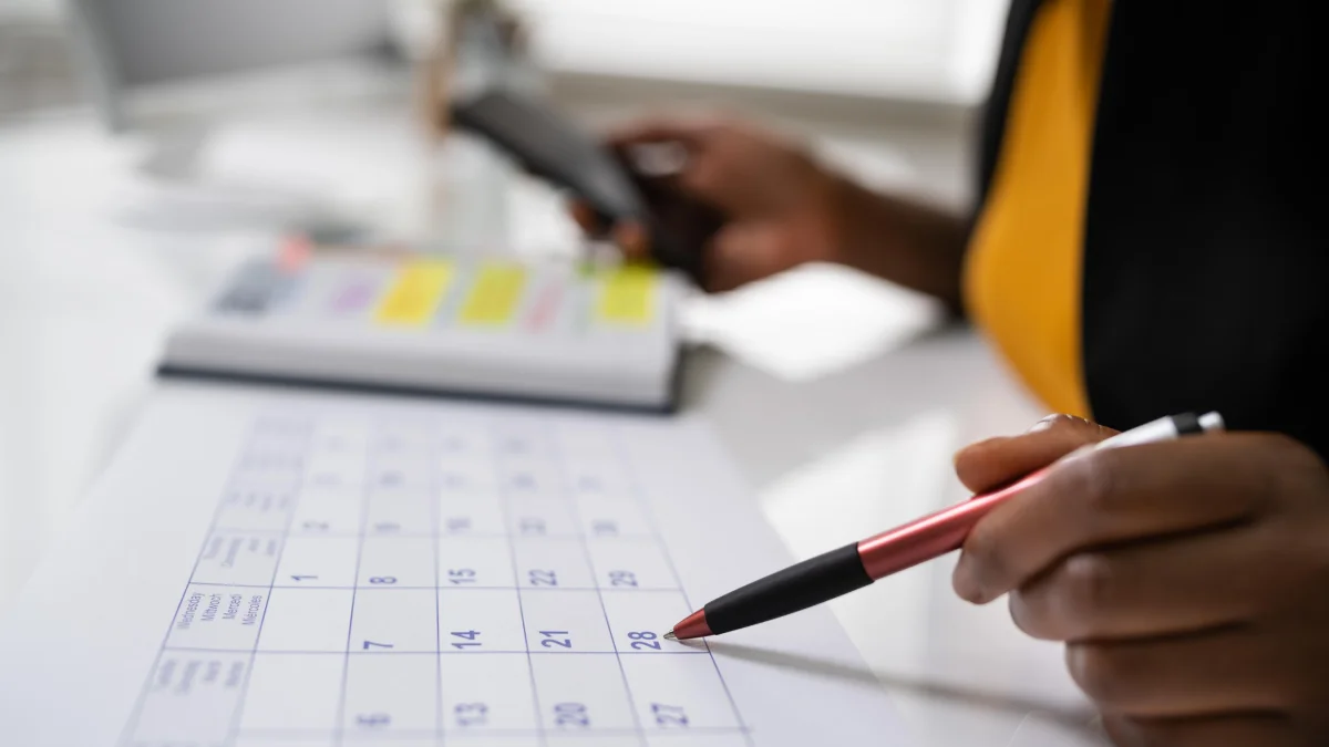 Woman at desk looking at date on calendar
